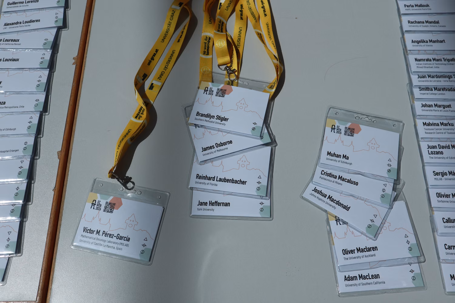 Nametags attached to yellow lanyards scattered on a table, showcasing a simple but playful design.